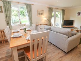 A living room with a dining area and a sofa at Sild Cottage in Falmouth