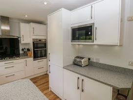 A kitchen with cabinets, a microwave, and a toaster at Glebe House in Bigbury