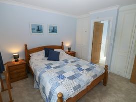 A bedroom with a bed and wardrobe at Glebe House in Bigbury
