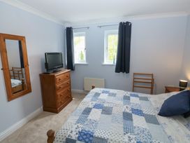 A bedroom with a bed and television at Glebe House in Bigbury
