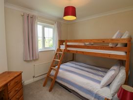 A bedroom with a bunk bed and a double bed at Glebe House Bigbury