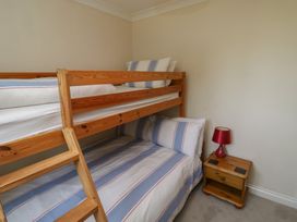 A bedroom with a bunk bed and bedside table at Glebe House in Bigbury