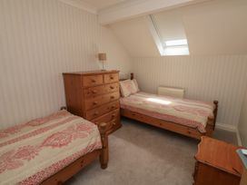 A bedroom with twin beds and a dresser at Glebe House in Bigbury