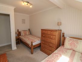 A bedroom with two single beds and a dresser at Glebe House in Bigbury