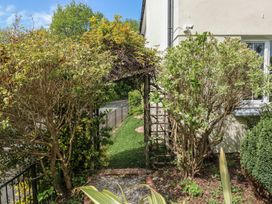 A garden pathway with shrubs and a trellis at Glebe House in Bigbury