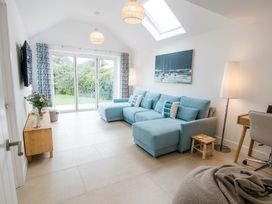 A living room with a blue sofa and glass door at Lanesend in St Agnes