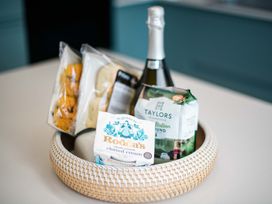 A basket with a bottle of sparkling wine and baked goods at Lanesend St Agnes