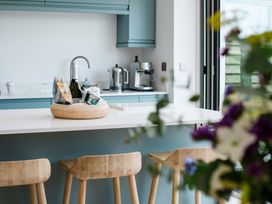 A kitchen with a basket of snacks and champagne at Lanesend in St Agnes