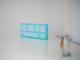 A sign with the text 'Rise and shine it's beach walkin' time' at Lanesend in St Agnes