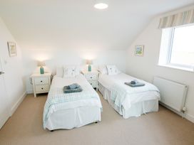A bedroom with two beds and bedside tables at Lanesend in St Agnes