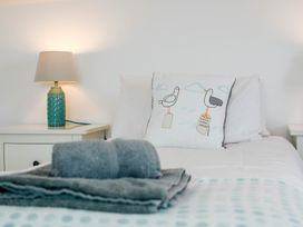 A bedroom with a lamp and decorative pillow at Lanesend in St Agnes