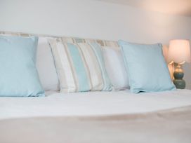 A bed with pillows and a lamp at Lanesend St Agnes