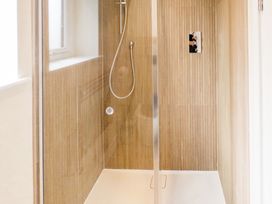 A shower with glass door and tiles at Lanesend in St Agnes