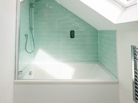 A bathroom with a bathtub and shower area at Lanesend St Agnes