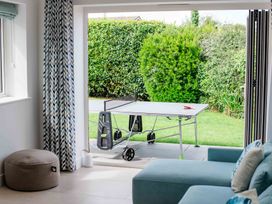 A living room with a table tennis table and sofa at Lanesend in St Agnes