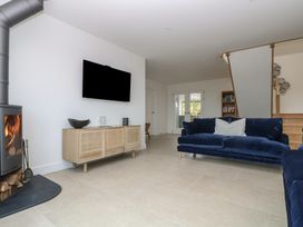 A living room with a sofa and wood stove at Lanesend in St Agnes