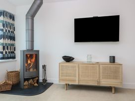 A living room with a fireplace and television at Lanesend in St Agnes