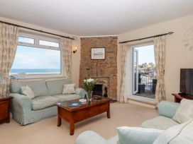 A living room with a sofa and television at Blue Horizon in Brixham