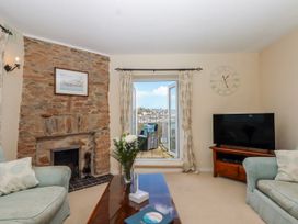 A living room with a fireplace and television at Blue Horizon in Brixham