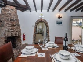 A dining room with a table set and a fireplace at Blue Horizon in Brixham