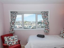 A bedroom with a window and armchair at Blue Horizon in Brixham