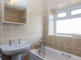 A bathroom with a bathtub and sink at Blue Horizon in Brixham