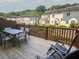 A deck with a table and chairs at Rosemary Cottage in Falmouth