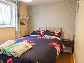 A bedroom with a bed with floral bedding and towels on it at The Old Hen Shed in Hainworth near Haworth