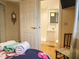 A bedroom with towels on a bed a chair and a view into a bathroom at The Old Hen Shed in Hainworth near Haworth
