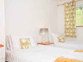 A bedroom with two beds and a lamp at Manorcombe 2 in Callington