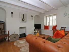 A living room with a sofa and television at Trelan in Mevagissey