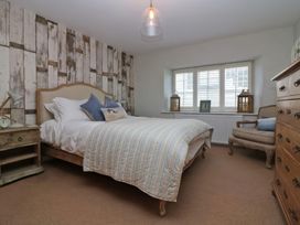 A bedroom with a bed and nightstands at Trelan in Mevagissey