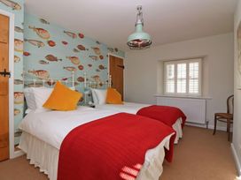 A bedroom with two beds and a fish wallpaper at Trelan in Mevagissey