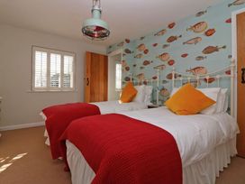 A bedroom with two beds and fish wallpaper at Trelan in Mevagissey