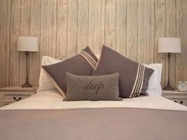 A bedroom with pillows and lamps on the nightstands at Trelan in Mevagissey