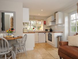 A kitchen with a table and chairs at Stocks Barn in Looe