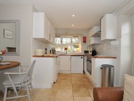 A kitchen with a window, appliances and a table at Stocks Barn Looe