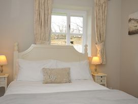 A bedroom with a bed and lamps at Stocks Barn in Looe