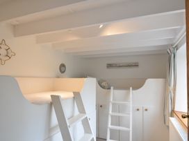 A bedroom with a bunk bed and a ladder at Stocks Barn Looe