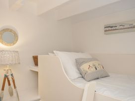 A bedroom with a bed and a lamp at Stocks Barn in Looe