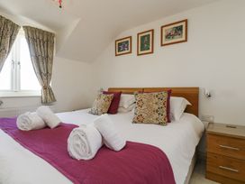 A bedroom with a bed and decorative pillows at Ridgeback House in Mullion