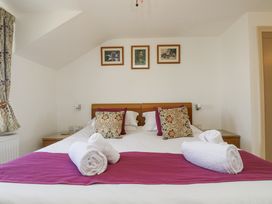 A bedroom with a bed and decorative pillows at Ridgeback House, Mullion