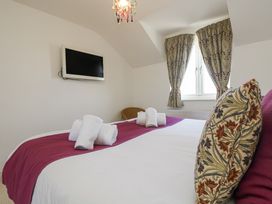 A bedroom with a bed and television at Ridgeback House in Mullion
