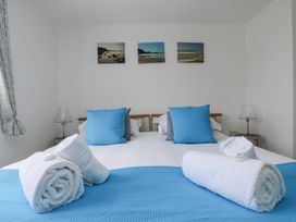A bedroom with a bed and towels arranged at Ridgeback House in Mullion
