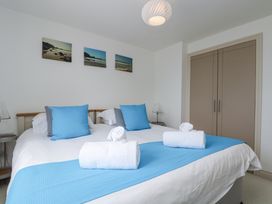 A bedroom with a bed and cupboard at Ridgeback House in Mullion