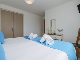 A bedroom with a bed and lamp at Ridgeback House in Mullion