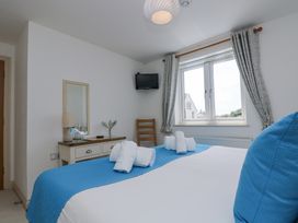 A bedroom with a bed and a window at Ridgeback House in Mullion