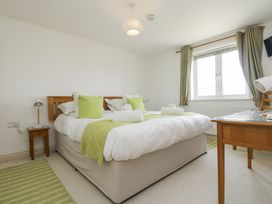 A bedroom with a bed and a table at Ridgeback House in Mullion