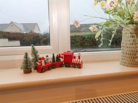 A decorative train and small trees on a windowsill at Ridgeback House in Mullion