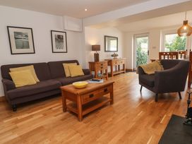 A living room with a sofa armchair wooden tables and framed pictures on the wall at Anneth Lowen in Angarrack near Hayle